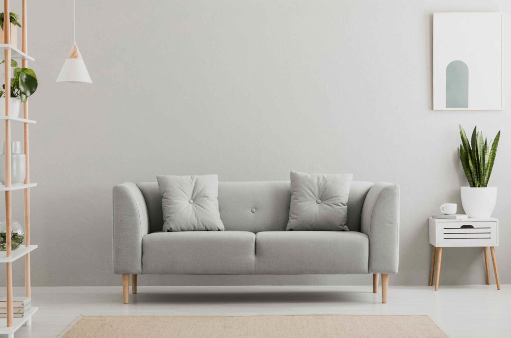 Poster,Above,White,Cabinet,With,Plant,Next,To,Grey,Sofa